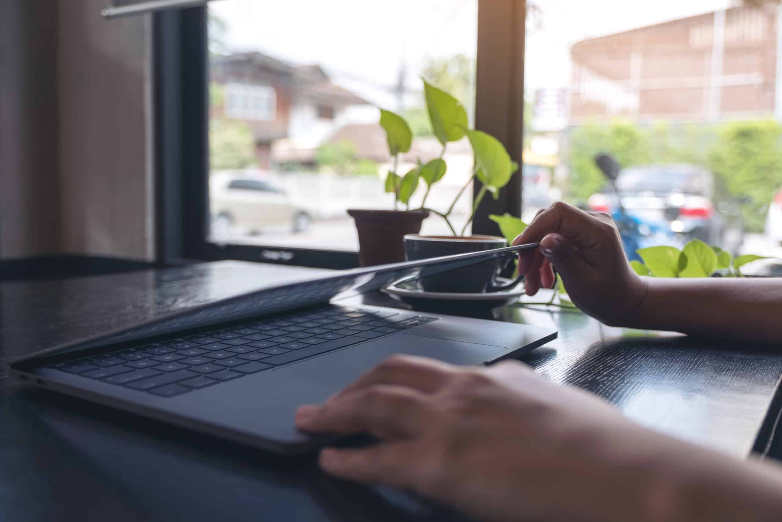 Closeup image of hands close and open a laptop computer on table